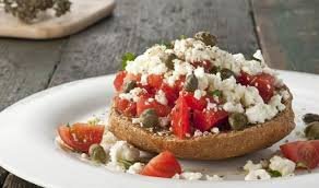 Traditional Cretan dakos salad with barley rusk, tomato, feta cheese, and olive oil.