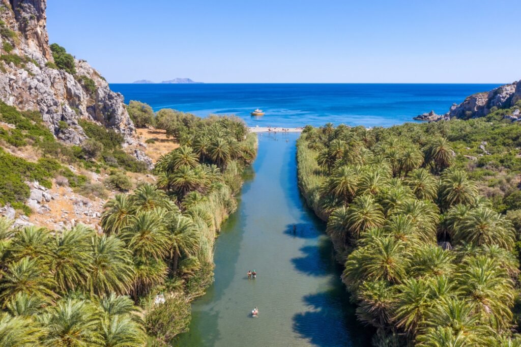 Preveli beach in Crete, Greece – river flowing into the sea surrounded by palm trees.